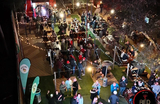 An overhead view of a busy Red Oak outdoor event at night.